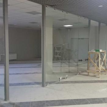Процесс установки стеклянной перегородки в торговом центре